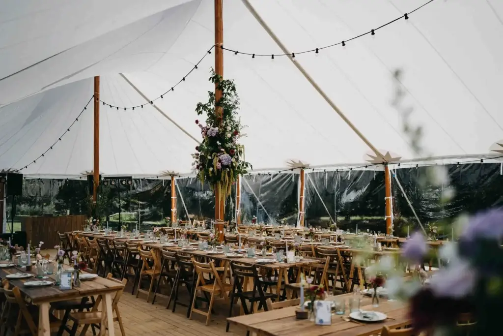 Lange gedekte tafels in een sailcloth tent