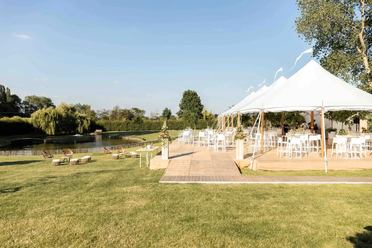Sailcloth tent aan een vijver met witte loungemeubels