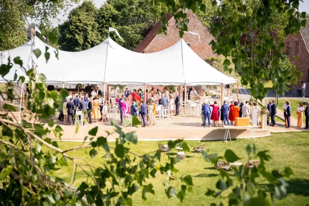 Sailcloth tent met trouwgasten op het erf van een hoeve